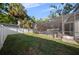 Backyard with a screen enclosed pool and patio area, surrounded by a lush lawn and white privacy fence at 4105 W Corona St, Tampa, FL 33629