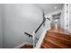 Wood stairs with white railing and a black handrail leads to the second floor landing at 4105 W Corona St, Tampa, FL 33629