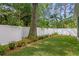 Landscaped backyard featuring a well-maintained lawn and a white vinyl fence for privacy at 4310 W Sevilla St, Tampa, FL 33629