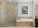 Bathroom with shower and soaking tub, a window overlooking a manicured lawn at 4310 W Sevilla St, Tampa, FL 33629