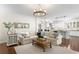 Open-concept living room featuring a light sofa, wood chandelier, and hardwood floors at 4310 W Sevilla St, Tampa, FL 33629