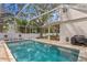 Inviting screened-in pool with turquoise water, patio, and outdoor grilling area at 4310 W Sevilla St, Tampa, FL 33629