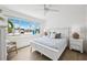Bright bedroom with a ceiling fan, large windows and light-colored furniture at 438 62Nd St, Holmes Beach, FL 34217
