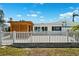 Charming single-story home featuring a modern pergola and white picket fence for added curb appeal at 438 62Nd St, Holmes Beach, FL 34217