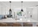 Bright kitchen with quartz countertops, blue backsplash, stainless steel appliances, and modern lighting at 438 62Nd St, Holmes Beach, FL 34217