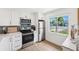 Modern kitchen with stainless steel appliances, white cabinetry, and a bright window with a lovely view at 438 62Nd St, Holmes Beach, FL 34217