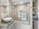 Bright bathroom offers a sleek vessel sink, marble countertop and glass shower with built-in shelves at 440 S Gulfview Blvd # 1701, Clearwater Beach, FL 33767