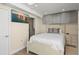 Cozy bedroom with a queen-sized bed, mounted TV, gray cabinets and ensuite bathroom at 440 S Gulfview Blvd # 1701, Clearwater Beach, FL 33767