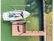 Aerial view of a boat dock with a boat lift and a boat at 540 115Th Ave, Treasure Island, FL 33706