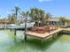 Well-maintained wooden boat dock equipped with a boat lift, seats, and a small table at 540 115Th Ave, Treasure Island, FL 33706