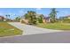 Long, concrete driveway leading to a well-maintained home with tropical landscaping and lush green lawn at 6181 9Th Avenue Ne Cir, Bradenton, FL 34212