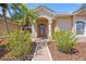 Charming front entrance with a decorative door, lush greenery, and a welcoming pathway at 6181 9Th Avenue Ne Cir, Bradenton, FL 34212