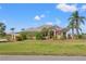 Inviting home featuring lush landscaping, a well-manicured lawn, and stately palm trees on a sunny day at 6181 9Th Avenue Ne Cir, Bradenton, FL 34212
