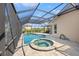 View of the pool and hot tub surrounded by a brick-paved deck and screen enclosure at 6181 9Th Avenue Ne Cir, Bradenton, FL 34212
