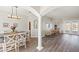 Open-concept space with wood floors, column accents, and a view of the dining area and lanai at 6181 9Th Avenue Ne Cir, Bradenton, FL 34212