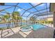 Screened-in pool area with a hot tub and views of a tranquil lake surrounded by palm trees at 6181 9Th Avenue Ne Cir, Bradenton, FL 34212