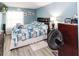 A bedroom with blue walls, a comfortable bed, and a floor fan for added comfort at 6188 Chesham Dr # 5, New Port Richey, FL 34653
