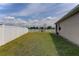 A spacious, grassy backyard with a white vinyl fence, offering privacy and a clear view at 6632 Laxey Ct, Zephyrhills, FL 33541