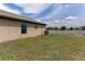 Lush backyard features a green lawn and a white fence, next to an air conditioning condenser at 6632 Laxey Ct, Zephyrhills, FL 33541
