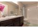 This bathroom has granite counters, a tub, and is decorated with a vase of flowers at 6632 Laxey Ct, Zephyrhills, FL 33541
