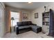 Cozy bedroom featuring a comfortable gray sectional sofa and a well-lit bookshelf at 6632 Laxey Ct, Zephyrhills, FL 33541