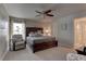 Bedroom with a dark wood bed frame, a ceiling fan, and natural light from the window at 6632 Laxey Ct, Zephyrhills, FL 33541