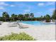 Resort-style community pool featuring lounge chairs and lush tropical landscaping, perfect for relaxation at 6632 Laxey Ct, Zephyrhills, FL 33541