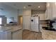 Well-lit kitchen with stainless steel sink, white cabinets, granite countertops and stainless steel appliances at 6632 Laxey Ct, Zephyrhills, FL 33541