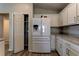 Kitchen area featuring white cabinets, stone countertops, pantry and stainless steel refrigerator at 6632 Laxey Ct, Zephyrhills, FL 33541