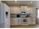 Well-lit kitchen featuring white appliances, matching cabinetry, and neutral countertops at 6632 Laxey Ct, Zephyrhills, FL 33541