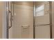 Walk-in shower with white tiled walls, safety bars, and a sliding glass door at 6632 Laxey Ct, Zephyrhills, FL 33541