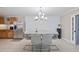 Bright dining area featuring a modern chandelier and a marble-topped table with white chairs at 904 Woodland Dr, Seffner, FL 33584