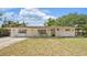 The house features an inviting front yard, white brick exterior, and ample parking space at 904 Woodland Dr, Seffner, FL 33584