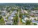 An aerial view captures a peaceful residential street lined with mature trees and houses some with pools in a suburban setting at 9044 Lynwood Dr, Seminole, FL 33772