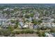 An aerial view shows mature trees and houses some with pools, situated in a well-established residential neighborhood at 9044 Lynwood Dr, Seminole, FL 33772