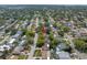Aerial view of a home in a residential neighborhood, surrounded by mature trees at 9044 Lynwood Dr, Seminole, FL 33772