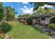 Expansive backyard with green grass, mature trees and lush plantings at 9044 Lynwood Dr, Seminole, FL 33772