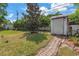 Spacious backyard with lush landscaping, storage shed, and privacy fence at 9044 Lynwood Dr, Seminole, FL 33772