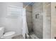Clean bathroom featuring a walk-in shower with tile surround and built-in niche, and a modern toilet at 9044 Lynwood Dr, Seminole, FL 33772