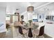 Elegant dining room with round table, modern light fixtures, and a view into the living space at 9044 Lynwood Dr, Seminole, FL 33772