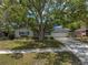 Well-maintained home featuring a large tree-shaded front yard and a two-car garage at 9044 Lynwood Dr, Seminole, FL 33772