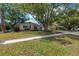 Charming single-story home featuring a large tree, two-car garage, and well-maintained lawn at 9044 Lynwood Dr, Seminole, FL 33772