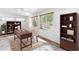 Inviting home office featuring a wooden desk, bookshelves, and a cozy rug on tiled floor at 9044 Lynwood Dr, Seminole, FL 33772