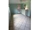 Entryway into living room with white door, ceiling fan, cabinet, and paneled walls at 9044 Lynwood Dr, Seminole, FL 33772