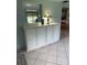 Living room featuring storage cabinet with countertop space, paneled walls, and neutral tile flooring at 9044 Lynwood Dr, Seminole, FL 33772