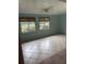 Bright living room featuring tile flooring, a ceiling fan, and two windows with exterior views and wood blinds at 9044 Lynwood Dr, Seminole, FL 33772