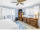 Cozy main bedroom with blue walls, dresser, ceiling fan, and bright windows with sheer curtains at 9044 Lynwood Dr, Seminole, FL 33772