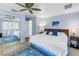 Serene main bedroom featuring blue walls, a comfortable bed, mirrored closet doors and a ceiling fan at 9044 Lynwood Dr, Seminole, FL 33772