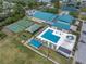 Aerial view of recreation center with swimming pool, playground, sports fields, and a modern gymnasium with turquoise accents at 9044 Lynwood Dr, Seminole, FL 33772