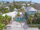 Aerial view of the turquoise home with palm trees and surrounding buildings, offering a tranquil coastal living environment at 106 23Rd Ave, St Pete Beach, FL 33706